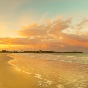 sunsetting on white shore beach